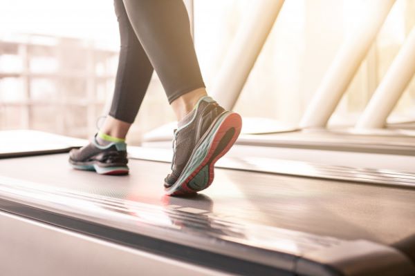 امرأة تركض على آلة الركض الرياضية-التشافي بالغذاء