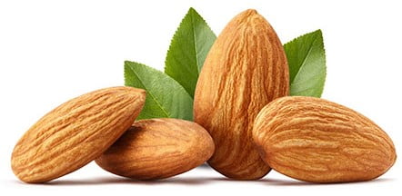 4 حبات من بذور اللوز على خلفية بيضاء-التشافي بالغذاء