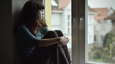 فتاة تعاني من القلق والاكتئاب، وتجلس بجوار النافذة-التشافي بالغذاء