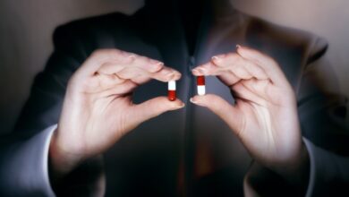 فتاة تحمل بكلتا يديها حبتان متشابهتان الأولى دواء وهمي والثانية حقيقي-التشافي بالغذاء