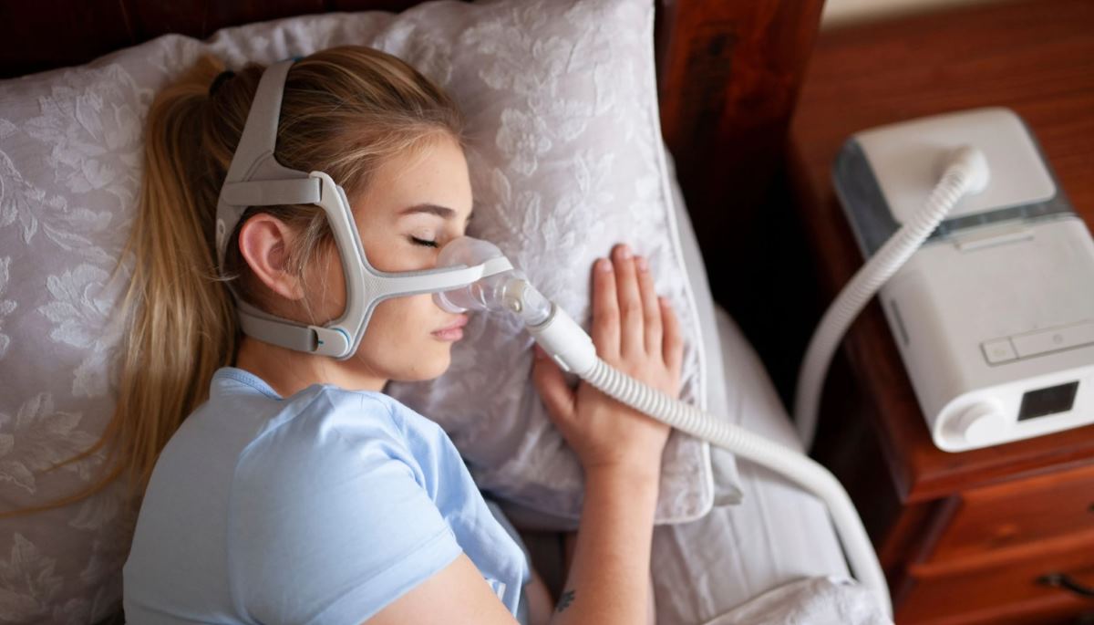 فتاة تستخدم جهاز CPAP للحد من انقطاع التنفس أثناء النوم-التشافي بالغذاء